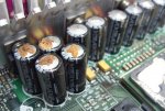 Nichicon_2200uF_6.3V_swollen_leaking_capacitors_Compaq_year_2001_motherboard.jpg
